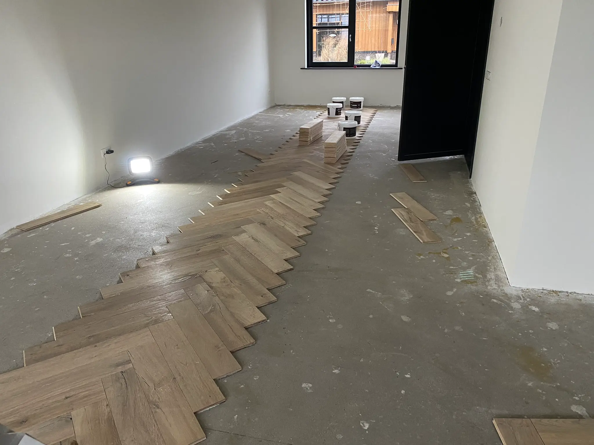 Montage houten visgraat parketvloer merk Raftwood kleur Ammazone eerste rij klaar door visser parket te rijssen