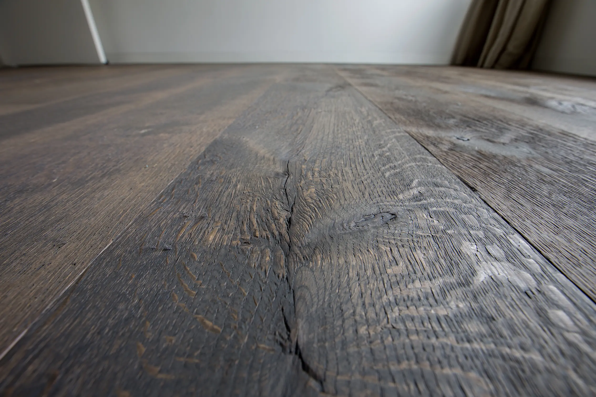 Houten vloer collectie Raftwood kleur donkerbruin met een mooie grote knoest van visser parket te rijssen