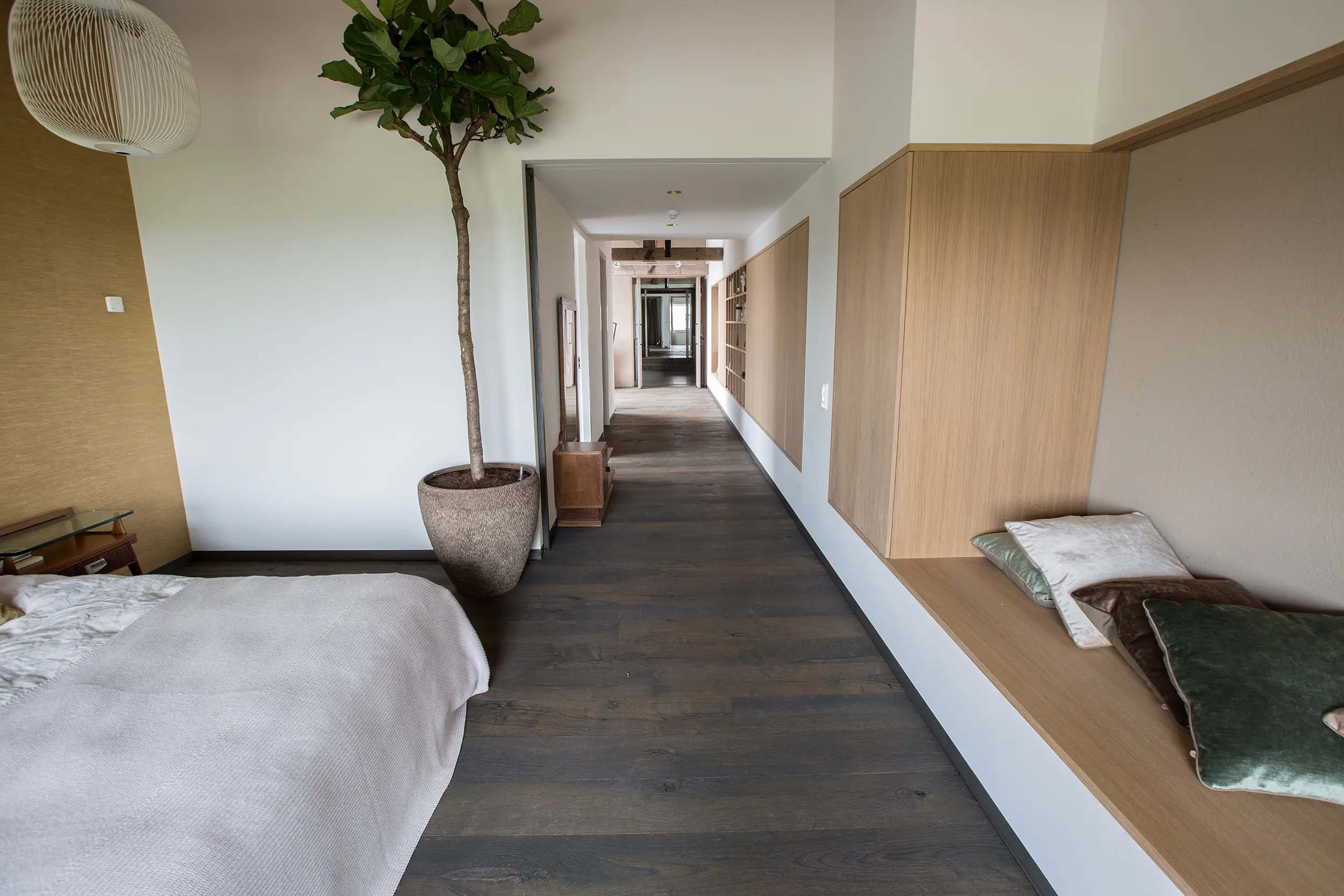 Houten vloer collectie Raftwood kleur donkerbruin met een bed op de voorgrond van visser parket te rijssen
